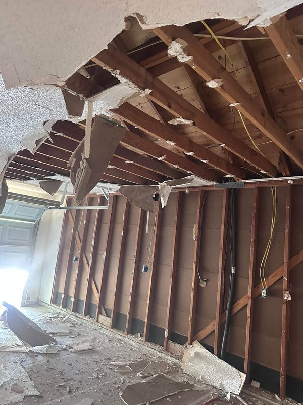 Ceiling joists and wall framing exposed during demo