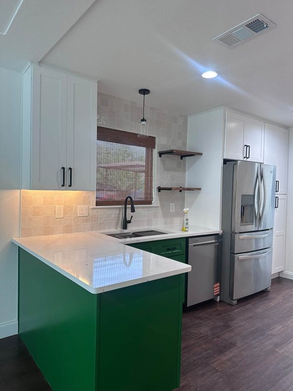 Peninsula with white quartz counter and green cabinets
