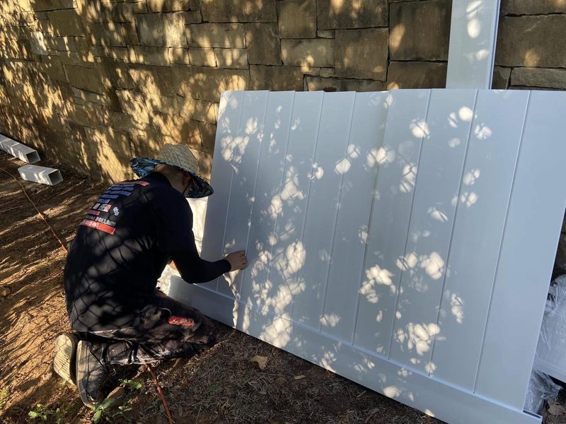 Setting a vinyl privacy fence panel