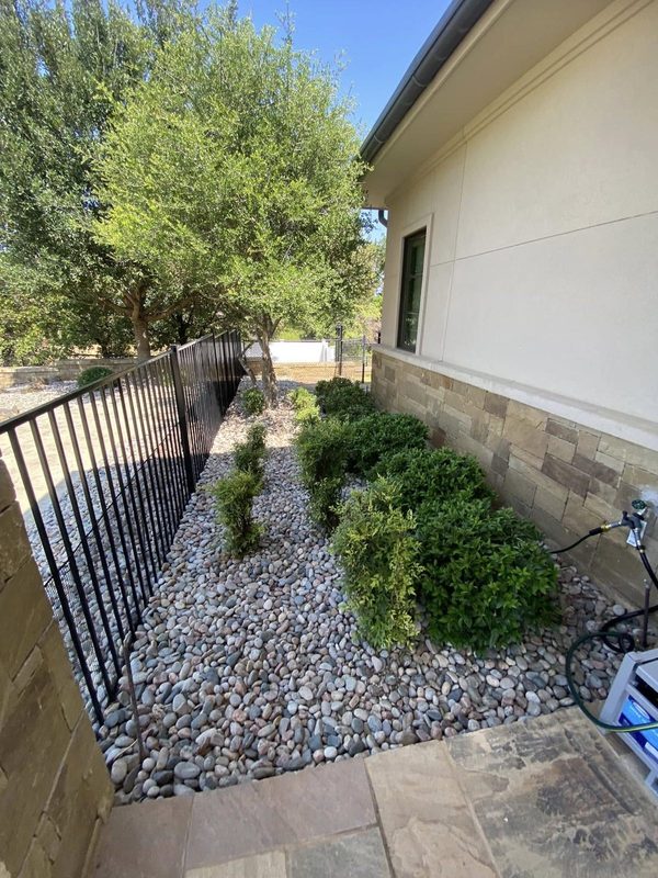 Rock bed running along stucco and stone elevation
