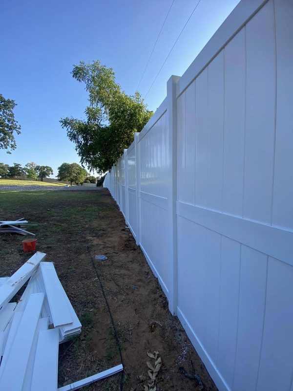 New vinyl privacy fence along an open yard