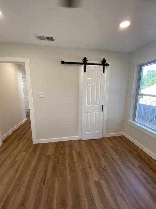 Barn door on a black rail over new plank floor