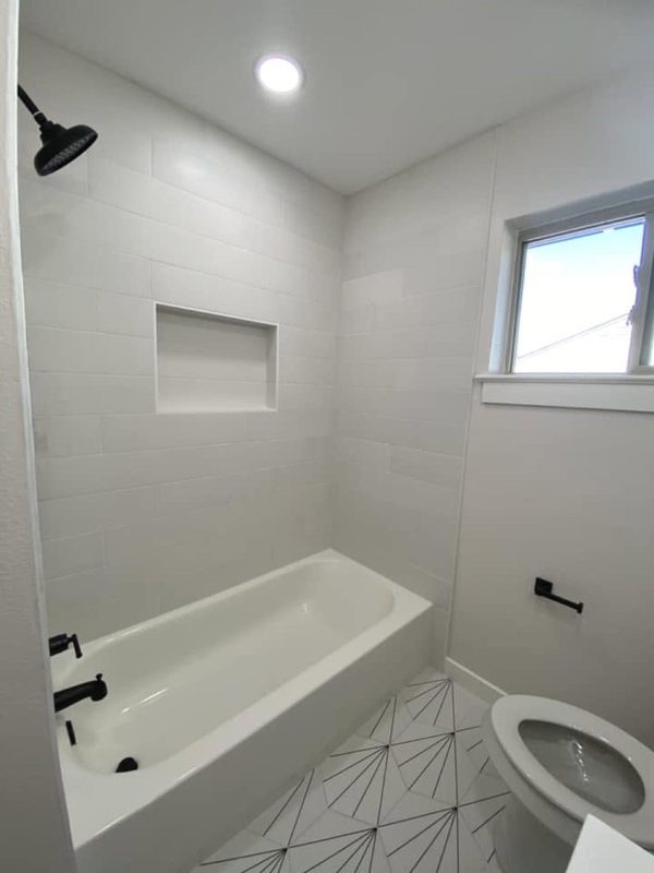 Tile tub surround with recessed niche and black fixtures