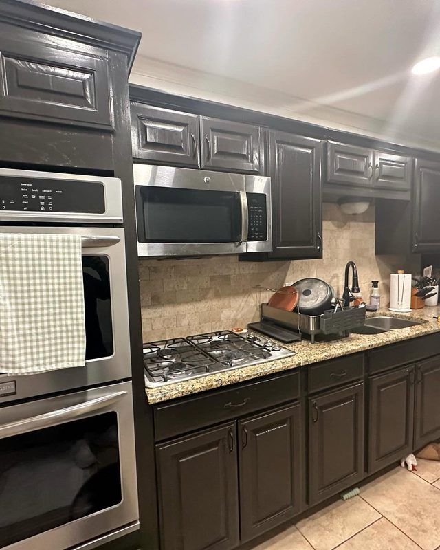 Dark cabinets, granite counters and stainless wall ovens