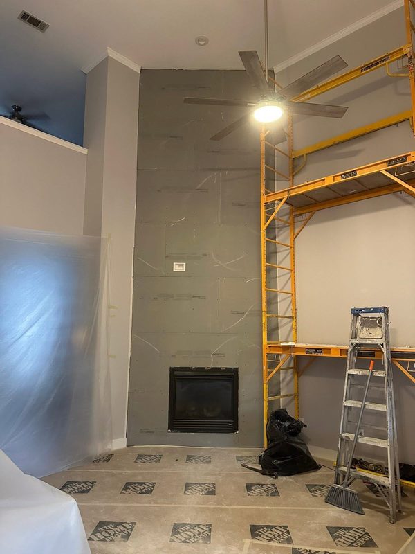 Fireplace surround under construction behind scaffolding