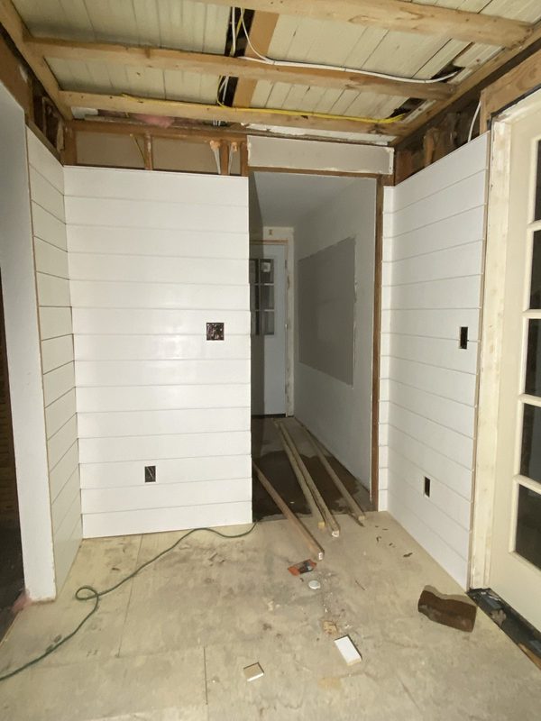 Shiplap going up in a hallway with the ceiling still open