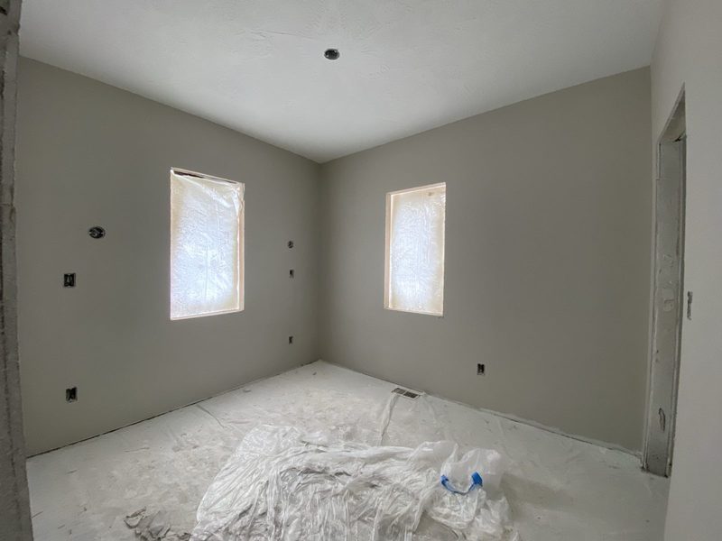 Bedroom walls primed with the floor covered